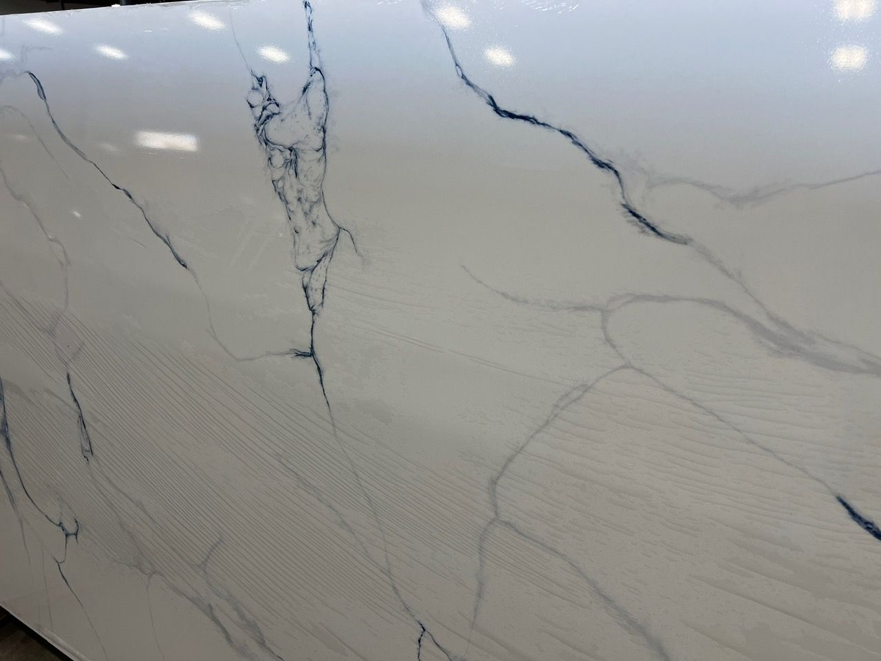 White marble surface with gray veining and subtle diagonal patterns