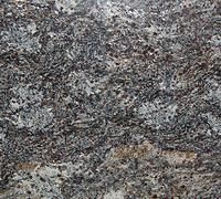 Close-up of a rough gray and black stone surface with speckled texture