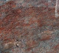 Close-up of a rough speckled stone surface in red, gray, and brown tones
