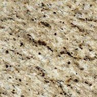 Close-up of beige speckled granite with dark mineral flecks and subtle diagonal veining