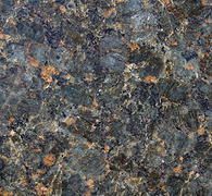 Close-up of speckled dark gray granite with flecks of brown and blue-gray
