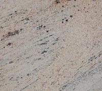 Close-up of light beige granite with dark speckles and faint diagonal streaks