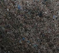 Close-up of dark, tangled fibers with small blue specks, filling the frame.