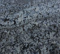 Gray and black speckled stone texture with a rough, uneven surface
