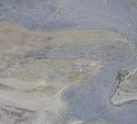 Abstract pale blue and beige marbled texture with wispy white streaks
