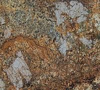 Close-up of rough gray and rust-colored stone with white mineral veins and speckled texture