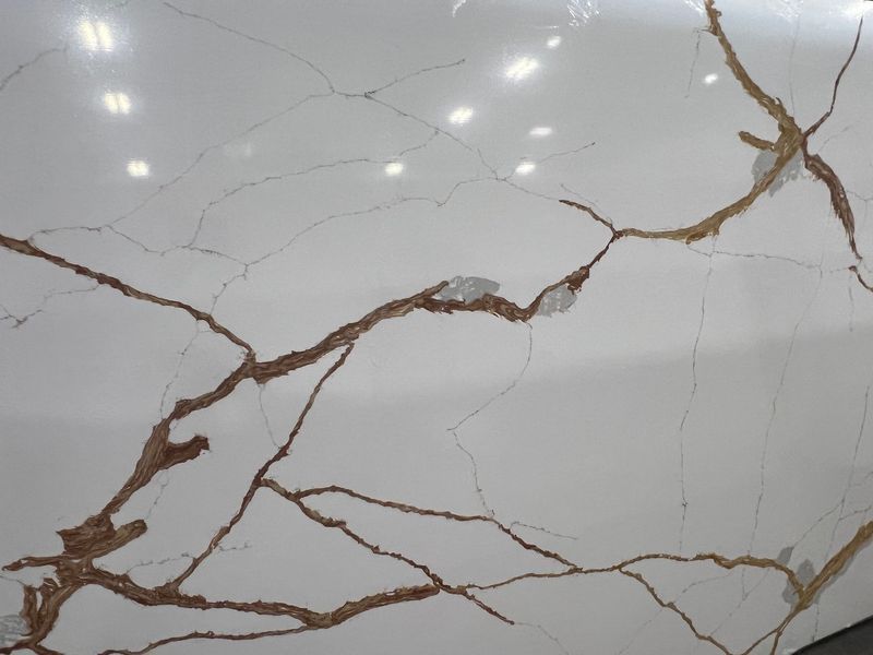 White marble surface with brown and gold veining and visible cracks