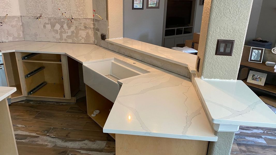 Large, unfinished beige reception desk in a modern interior with open shelves and stone flooring