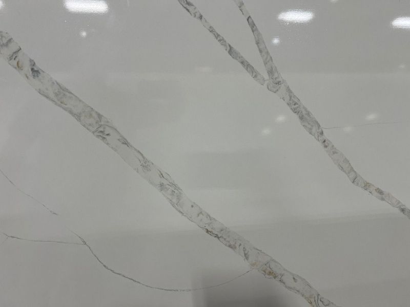 White marble surface with thin gray veining and glossy reflections