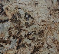 Mottled beige and brown granite surface with dark veining and speckled texture