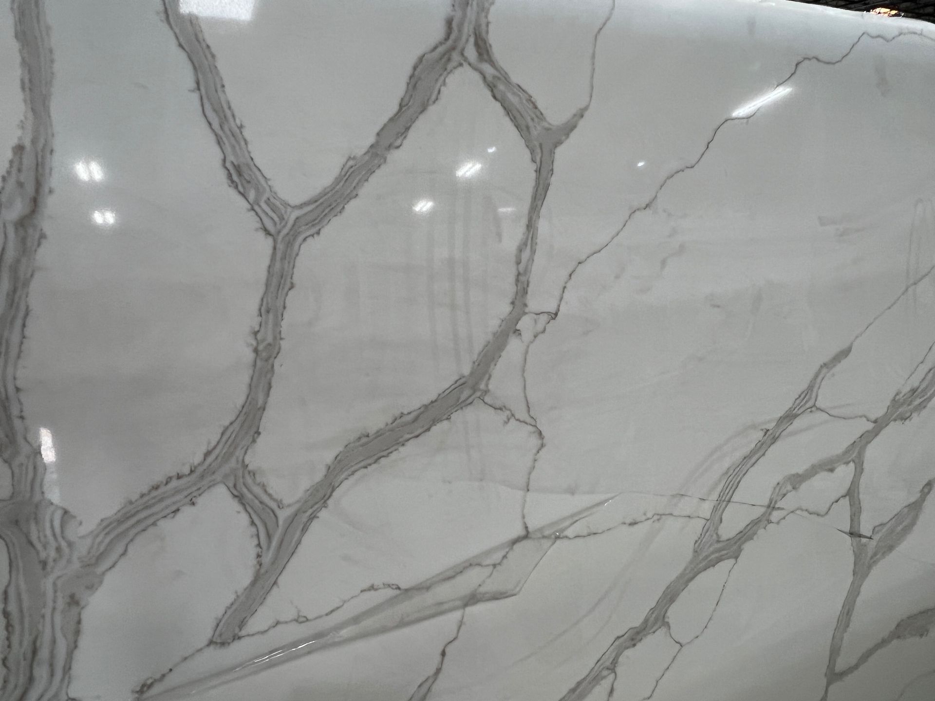 Gray marble tile with dark veining and a glossy surface