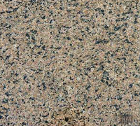 Close-up of a speckled tan, brown, and black stone or granite surface.
