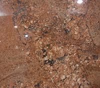 Close-up of rough reddish-brown soil with small pebbles and a few white stones.