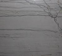 Gray marble wall with thin dark veins and a branching crack in the upper right.