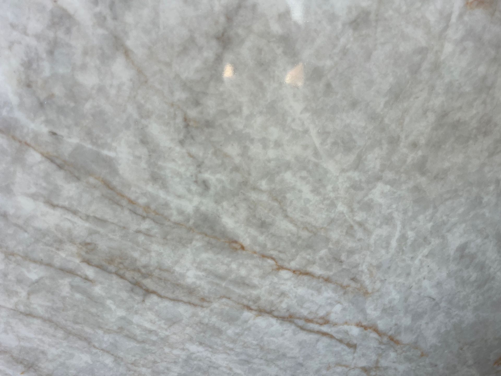 Close-up of light gray stone with subtle brown veins and texture