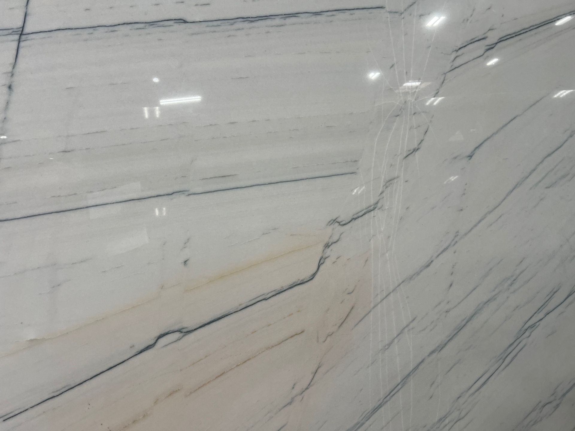 White marble wall with gray veining and a visible diagonal crack or seam