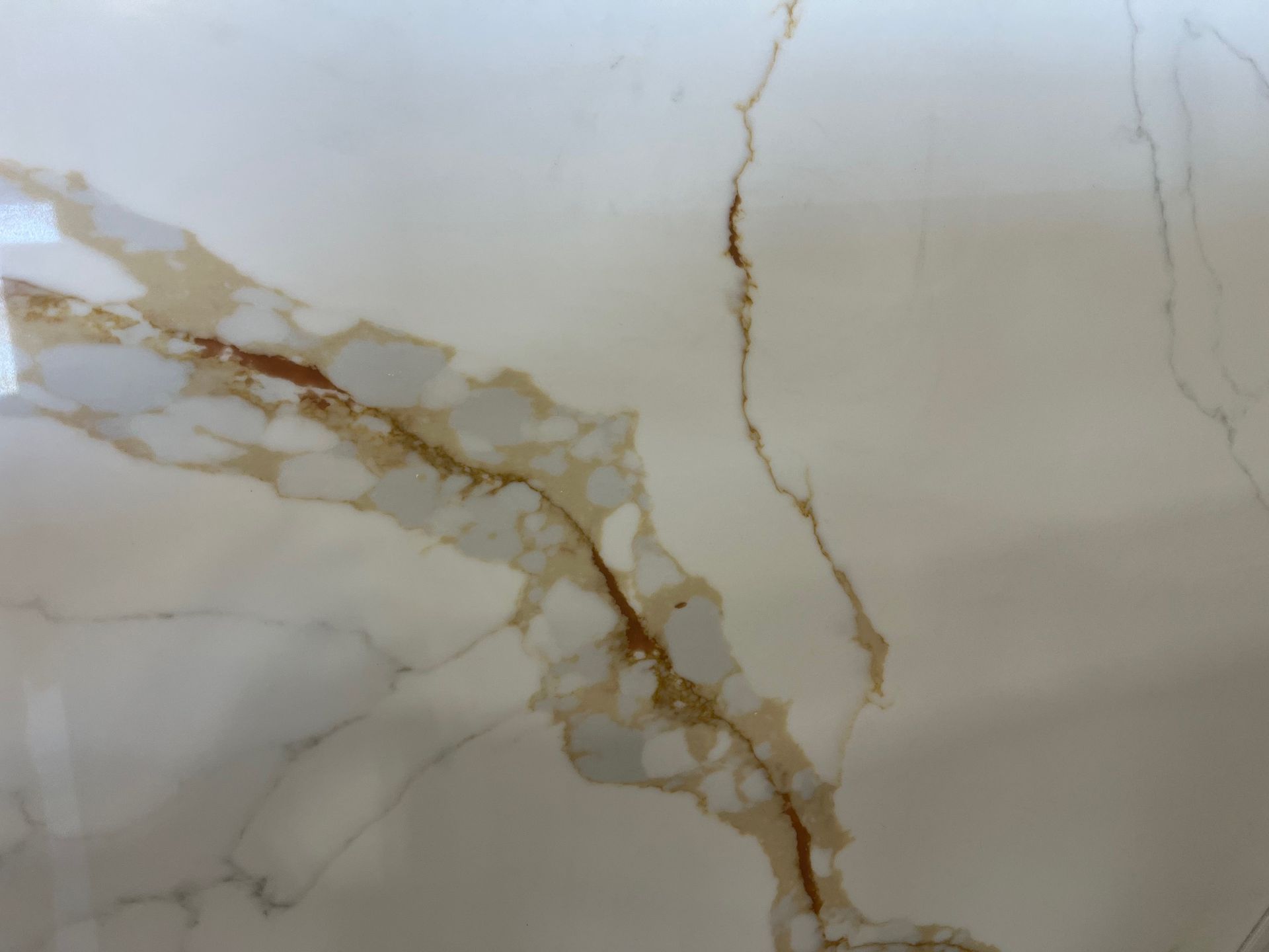 Close-up of white marble with tan and brown veining and a vertical crack