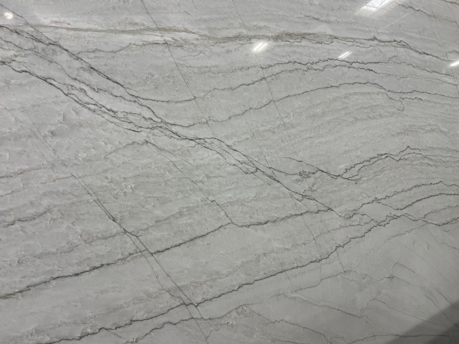Gray marble surface with subtle white veining and diagonal streaks