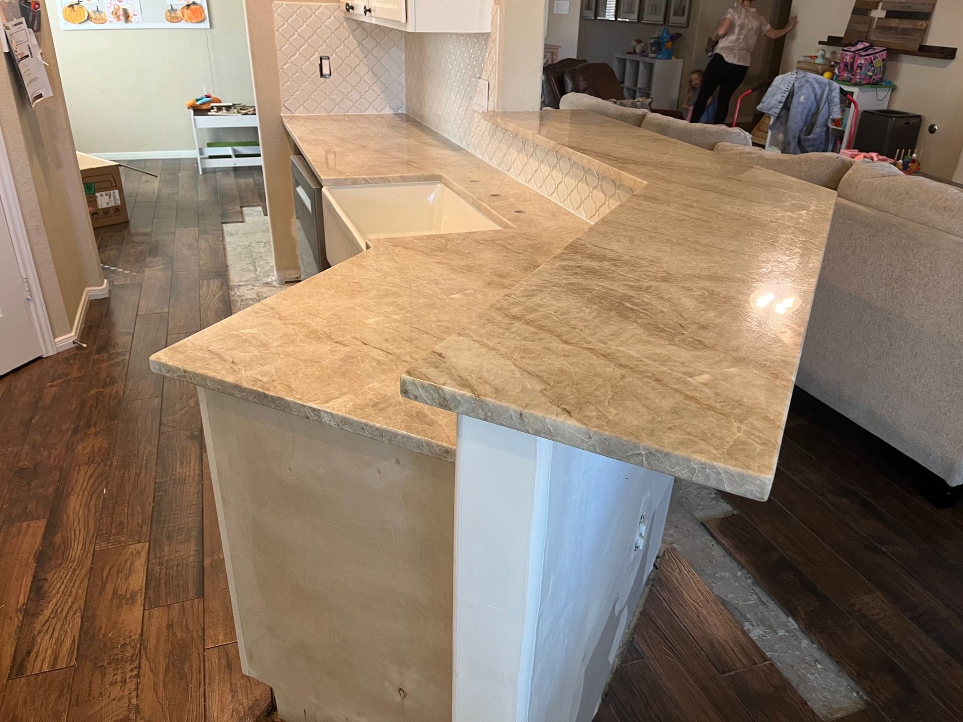 Light wood kitchen island with beige granite countertop in a modern home interior