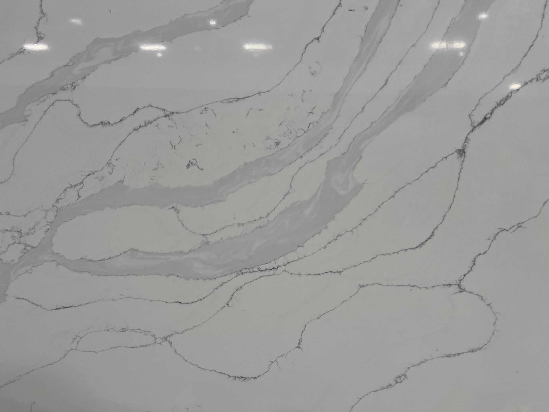 Light gray marble surface with subtle white veins and a glossy finish