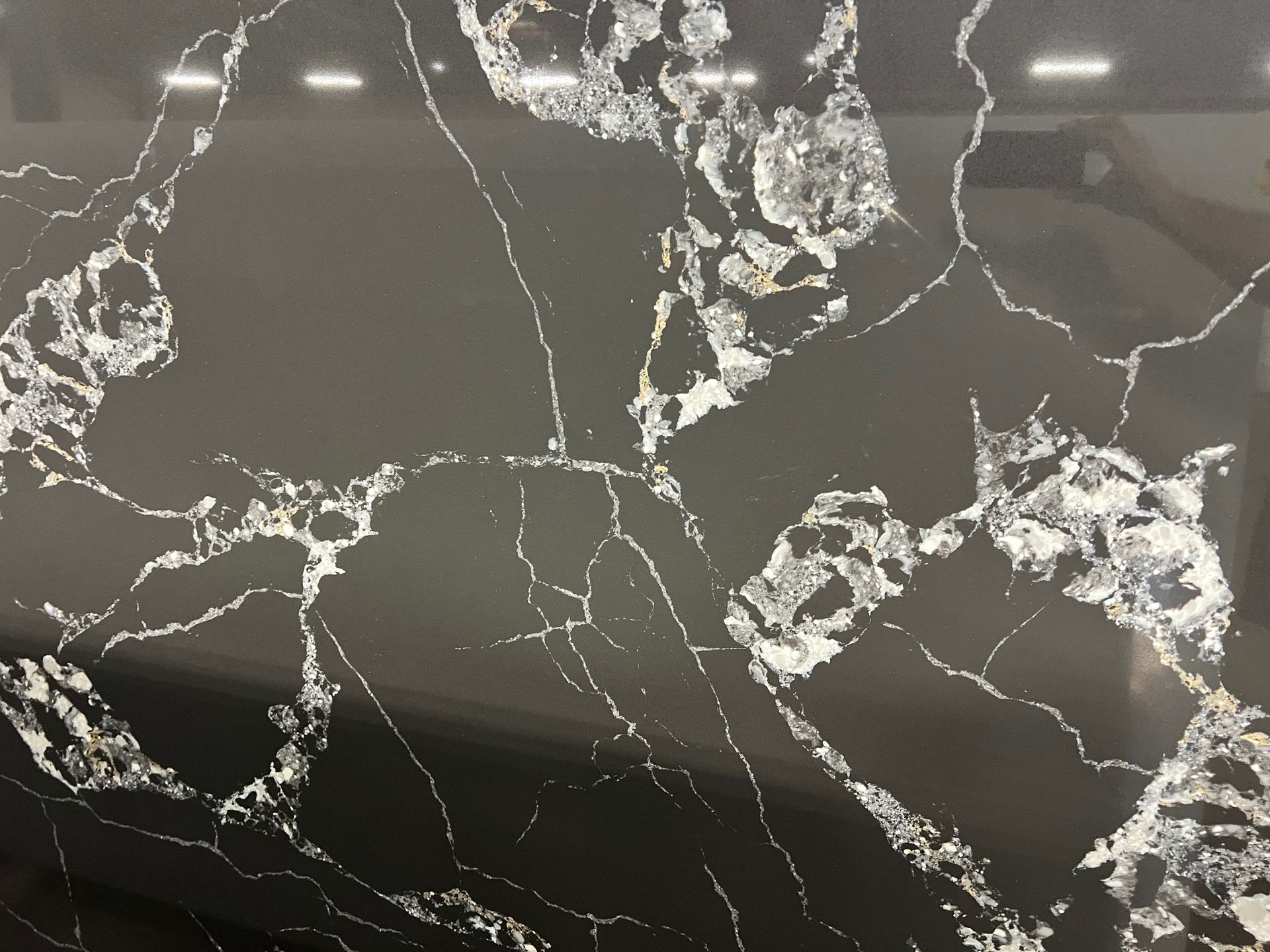 Black marble-like surface with white veining and reflective highlights