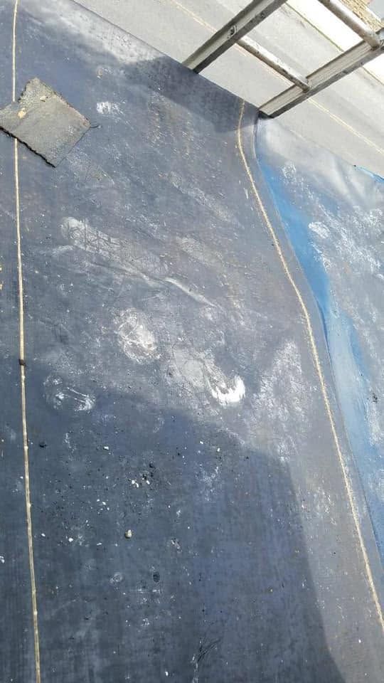Close-up of a blue, weathered surface with white scuffs and a metal frame at the top.