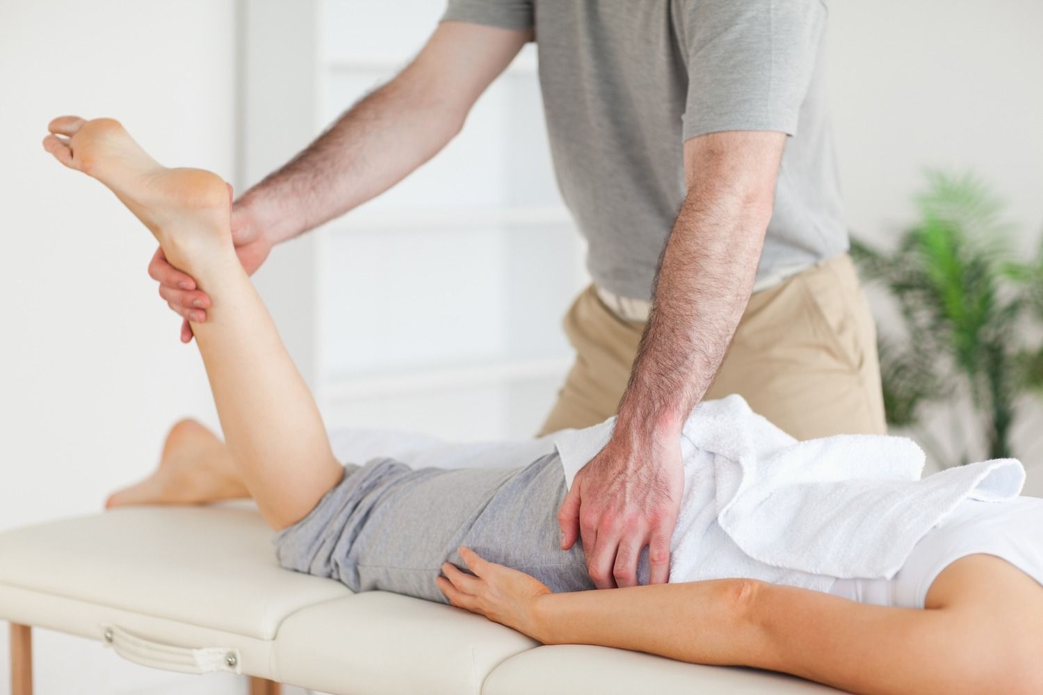 A Man Is Giving A Woman A Massage On A Table — Physiocare In Maroochydore, QLD