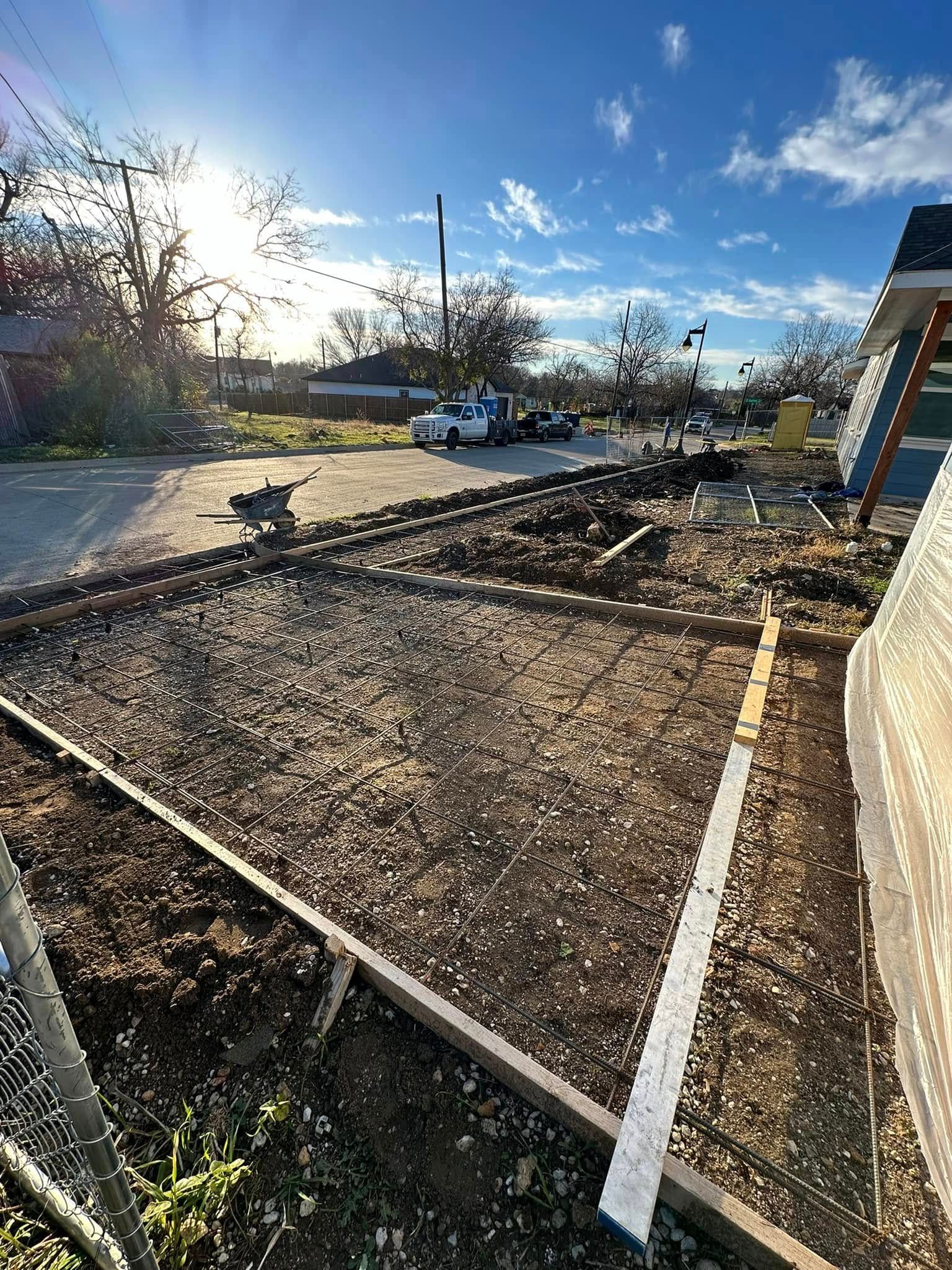 Construction site with concrete forms set. Gravel fill, sunny day.