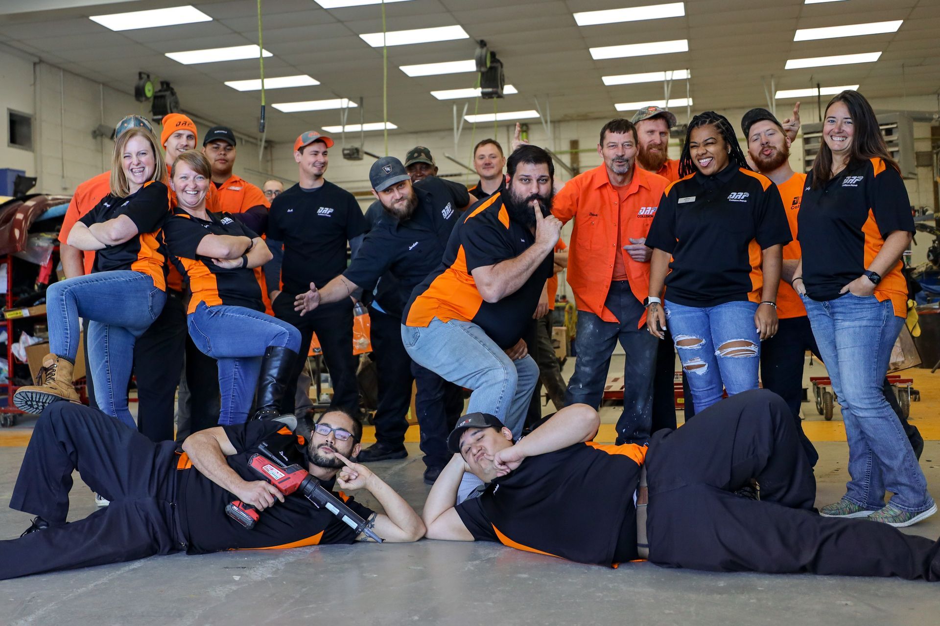 A group of people are posing for a picture in a garage.