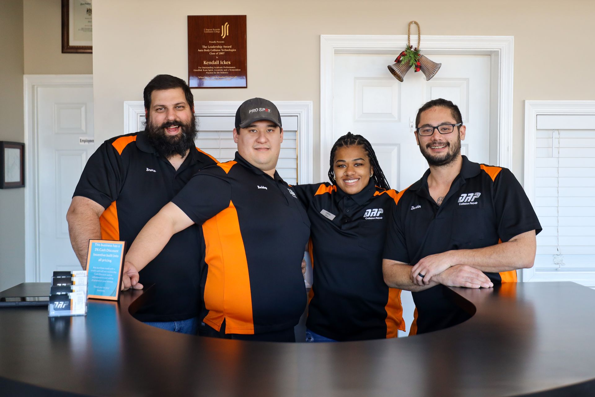A group of people are posing for a picture in front of a counter.