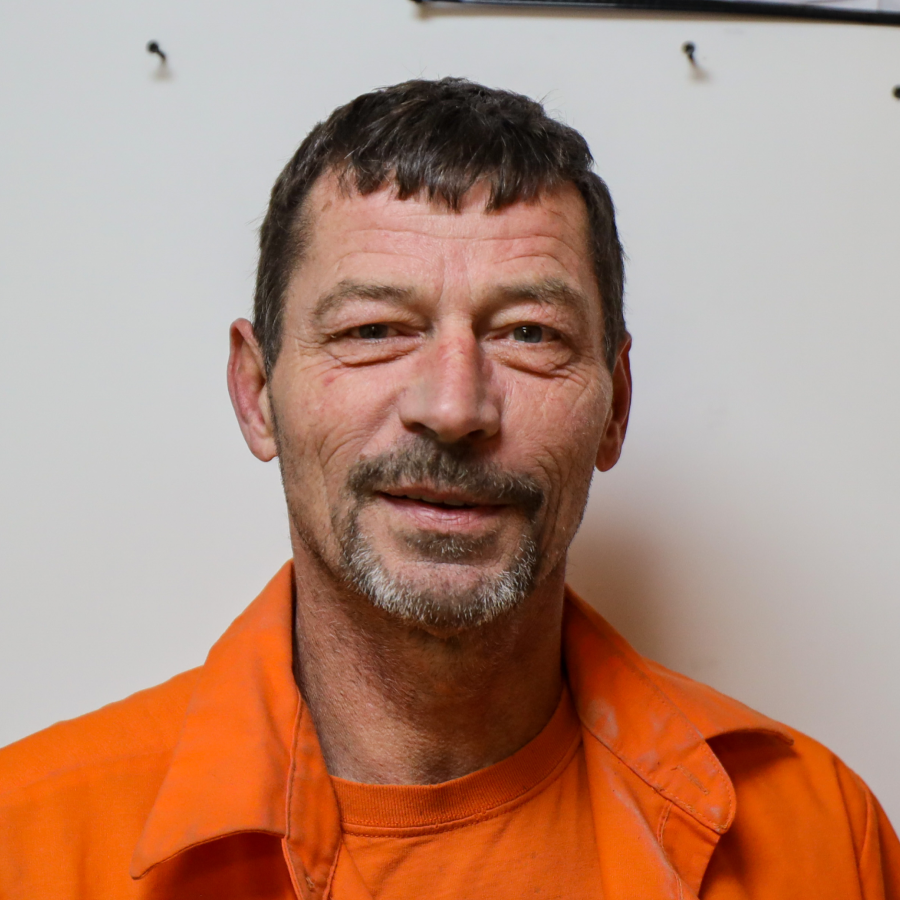 A man with a beard is wearing an orange shirt