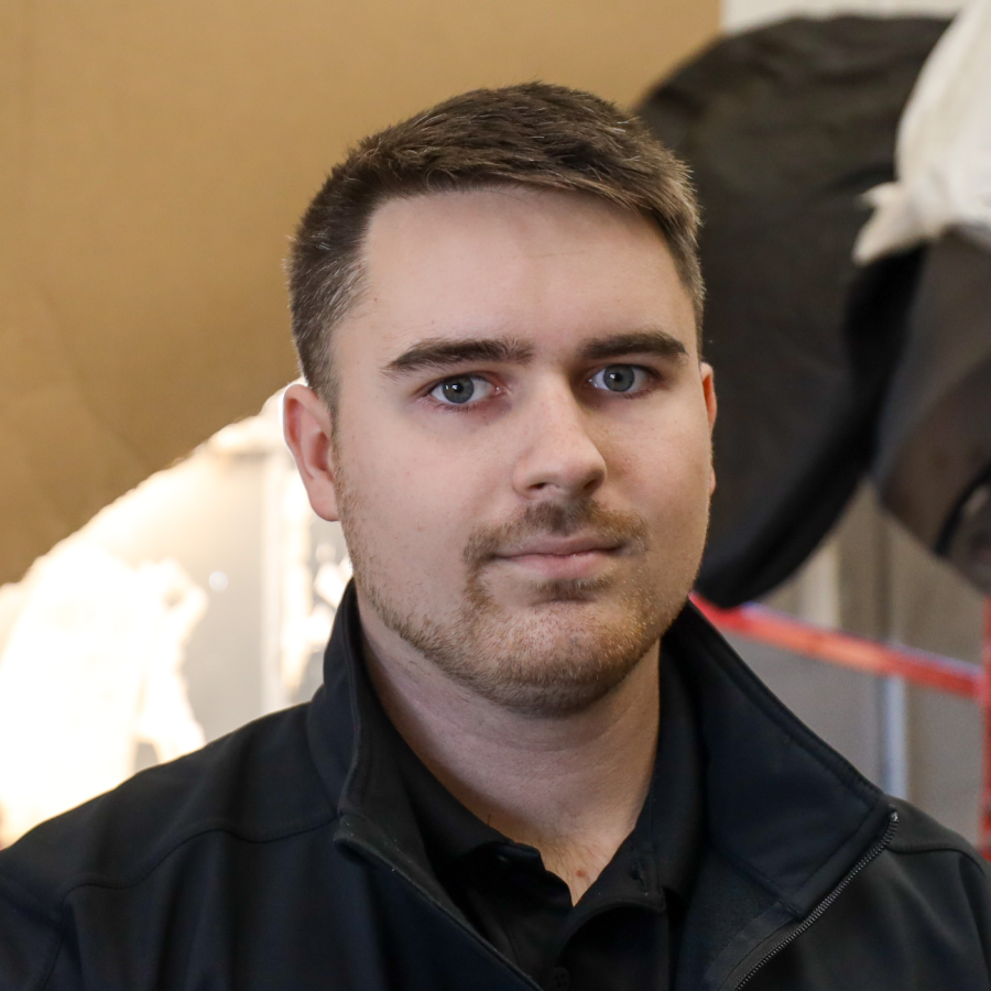 A man with a beard is wearing a black jacket
