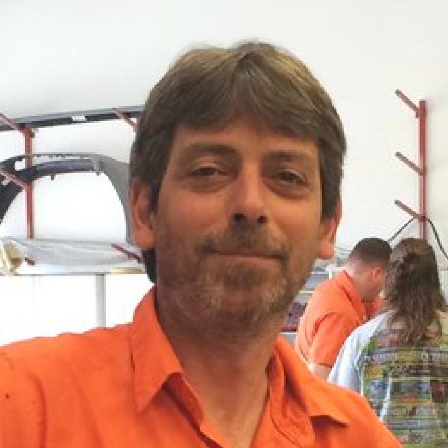 A man with a beard is wearing an orange shirt