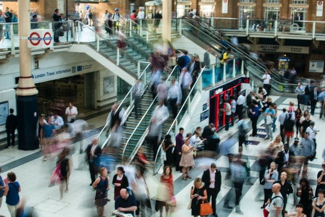 Des silhouettes floues en mouvement, descendant les escaliers mécaniques et les escaliers de la gare londonienne.