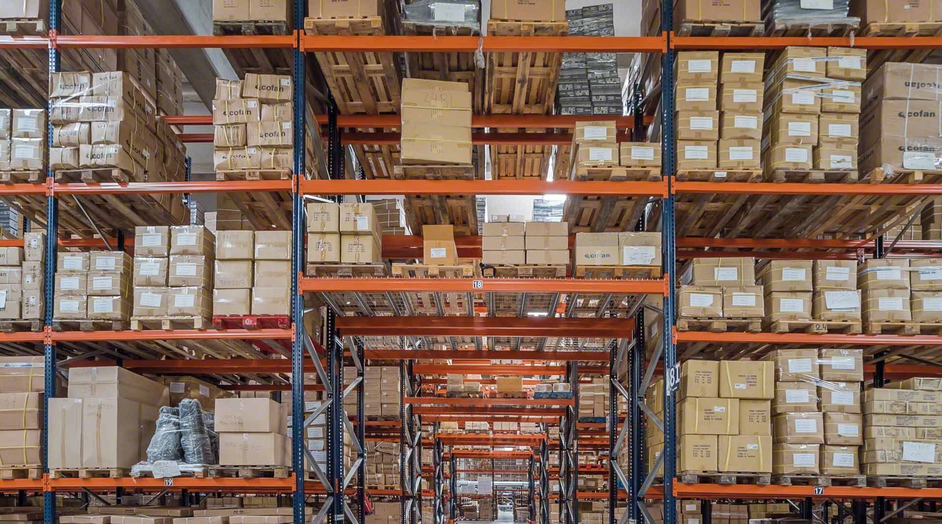Intérieur d'un entrepôt avec des rangées d'étagères remplies de cartons et de palettes.
