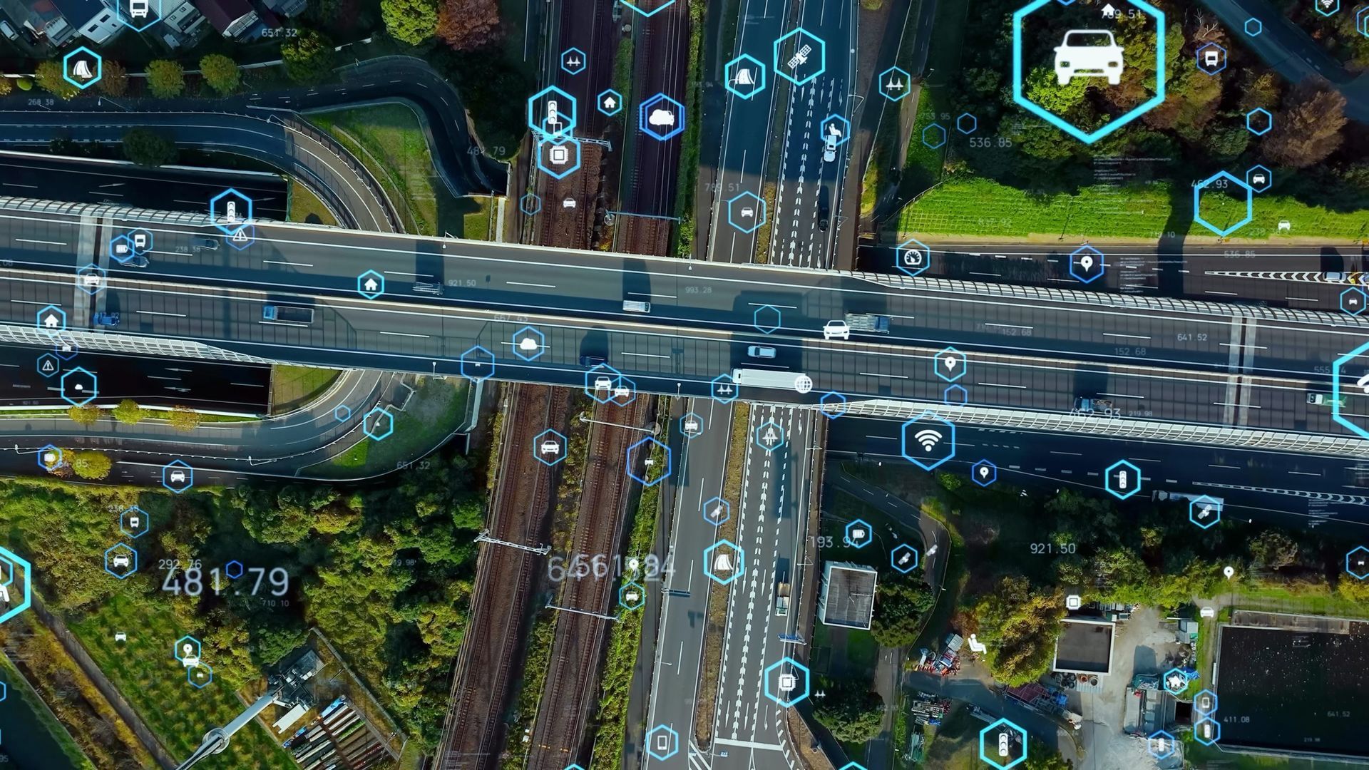Vue aérienne d'un échangeur autoroutier avec superposition de données, illustrant la gestion intelligente du trafic et les véhicules autonomes.
