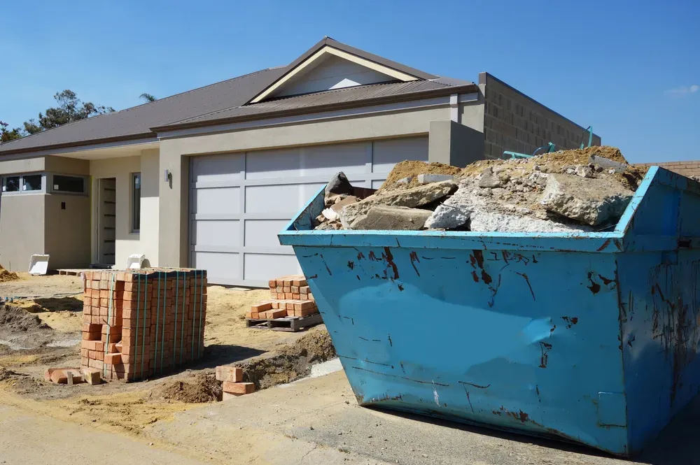 New home construction site with a blue dumpster full of debris and stacks of bricks. — Select Site Solutions in Kangaroo Valley, NSW