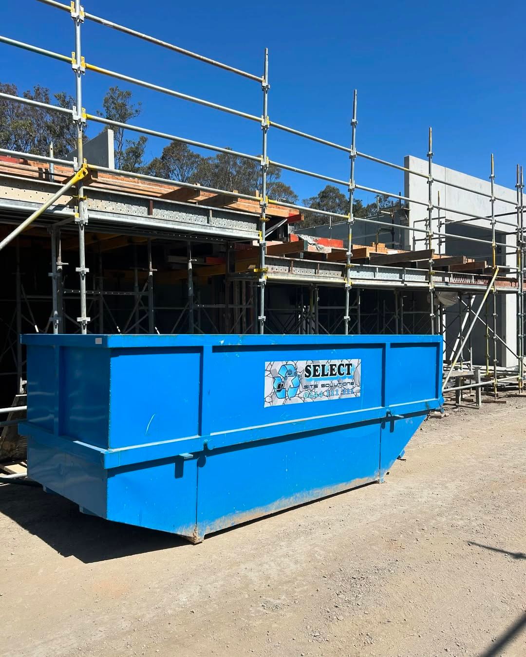 Blue Dumpster in Front of a Building Under Construction — Select Site Solutions in Jervis Bay, NSW