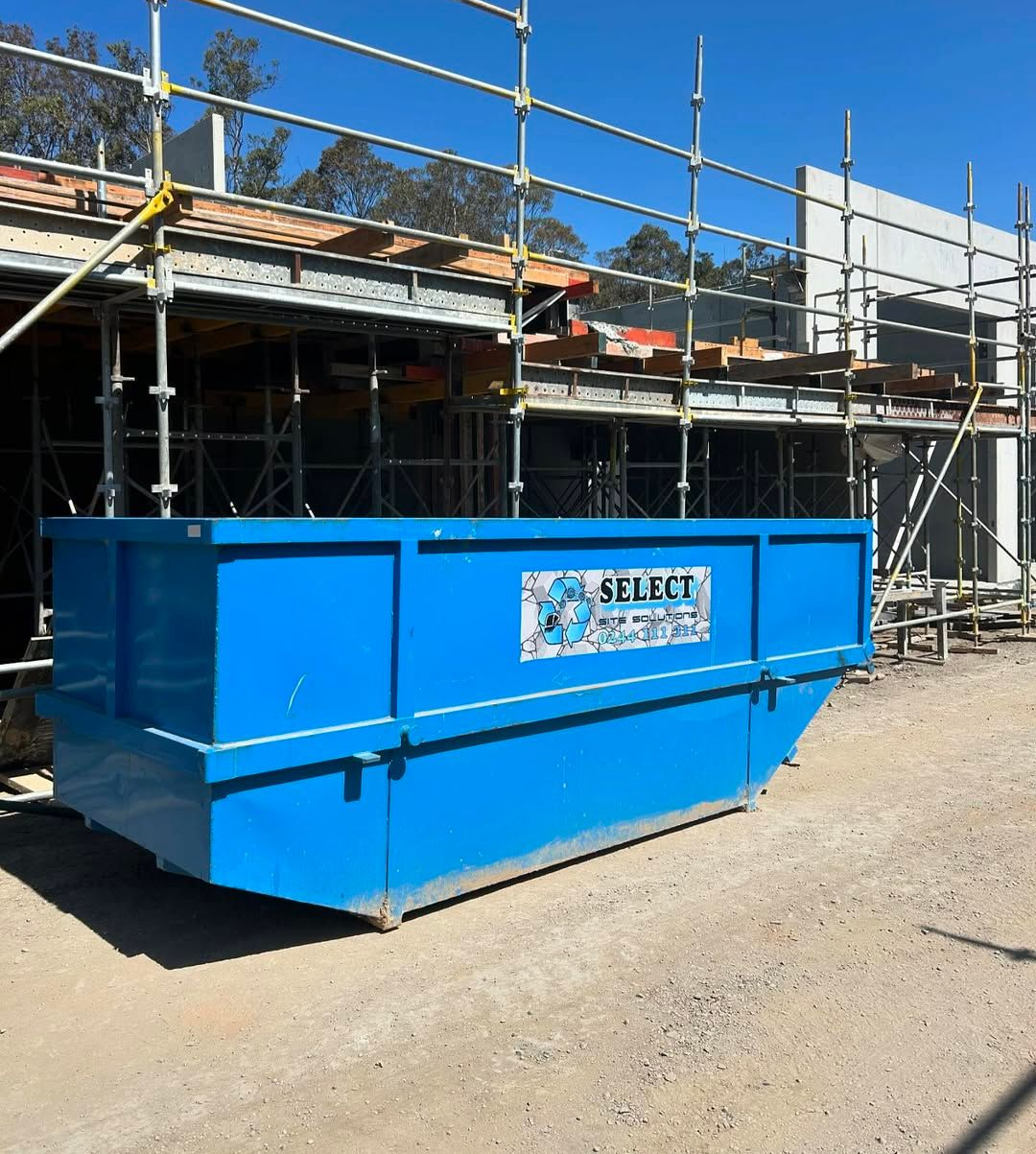 A Blue Skip Bin in Front of Scaffolding — Select Site Solutions in South Nowra, NSW