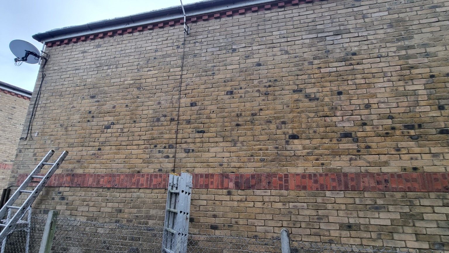 Graffiti on brickwork back of house removal complete