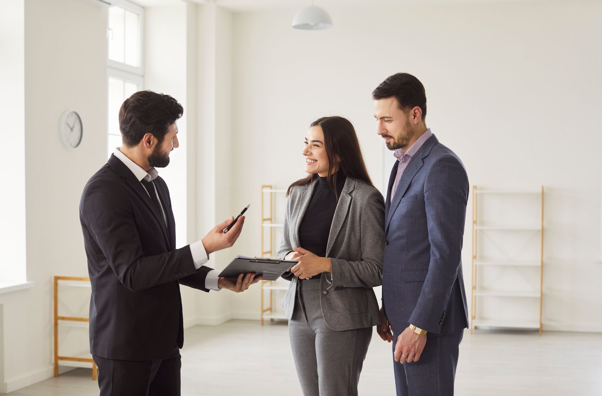 Three professionals discussing documents in a bright office interior.