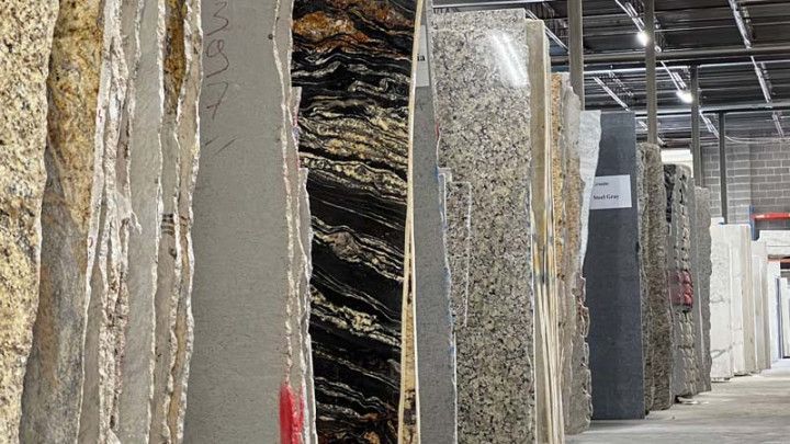 Rows of granite and stone slabs in a warehouse; various colors and patterns.