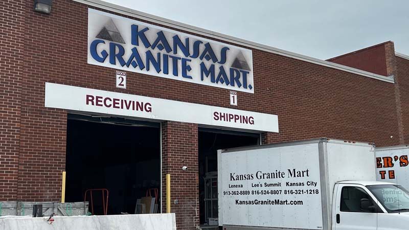 Exterior of Kansas Granite Mart building with loading docks. A delivery truck is parked at the shipping dock.