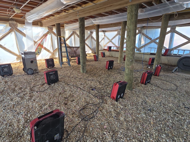 Dozens of commercial air movers and dehumidifiers running in a flooded Suffolk County crawlspace during a K.O.S. Restoration structural drying job