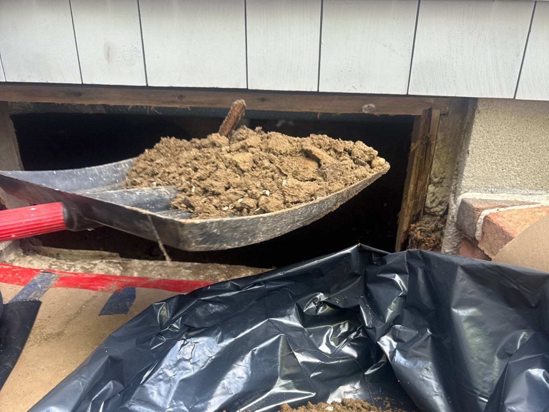 Removing contaminated material from crawlspace after sewage flooding at a home in Westhampton Beach, NY