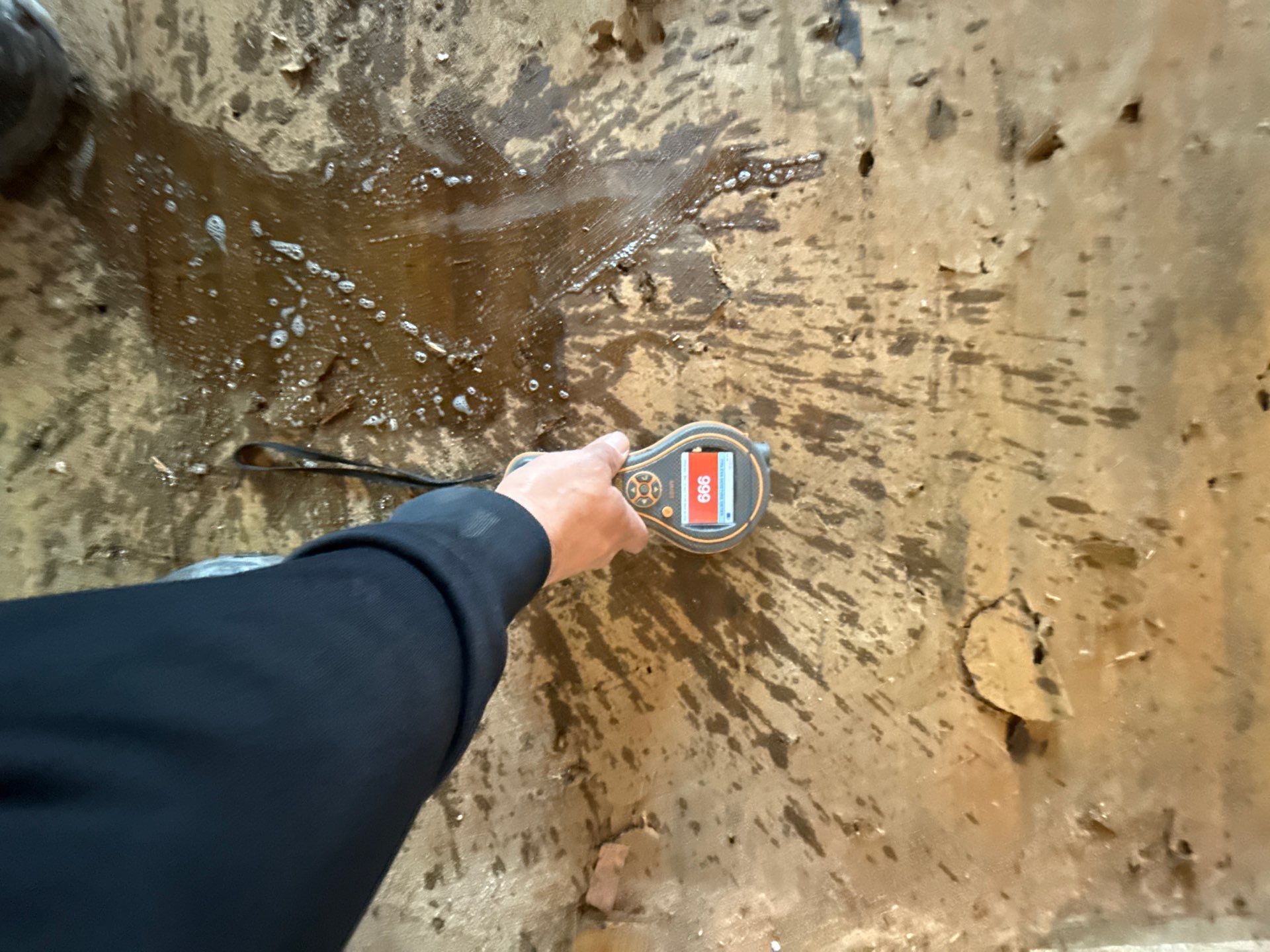 Taking moisture readings of wet flooring at a home in Patchogue NY
