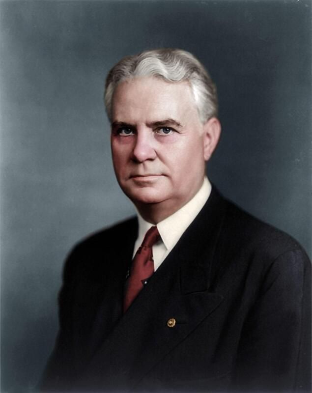 A man in a suit and tie is looking at the camera
