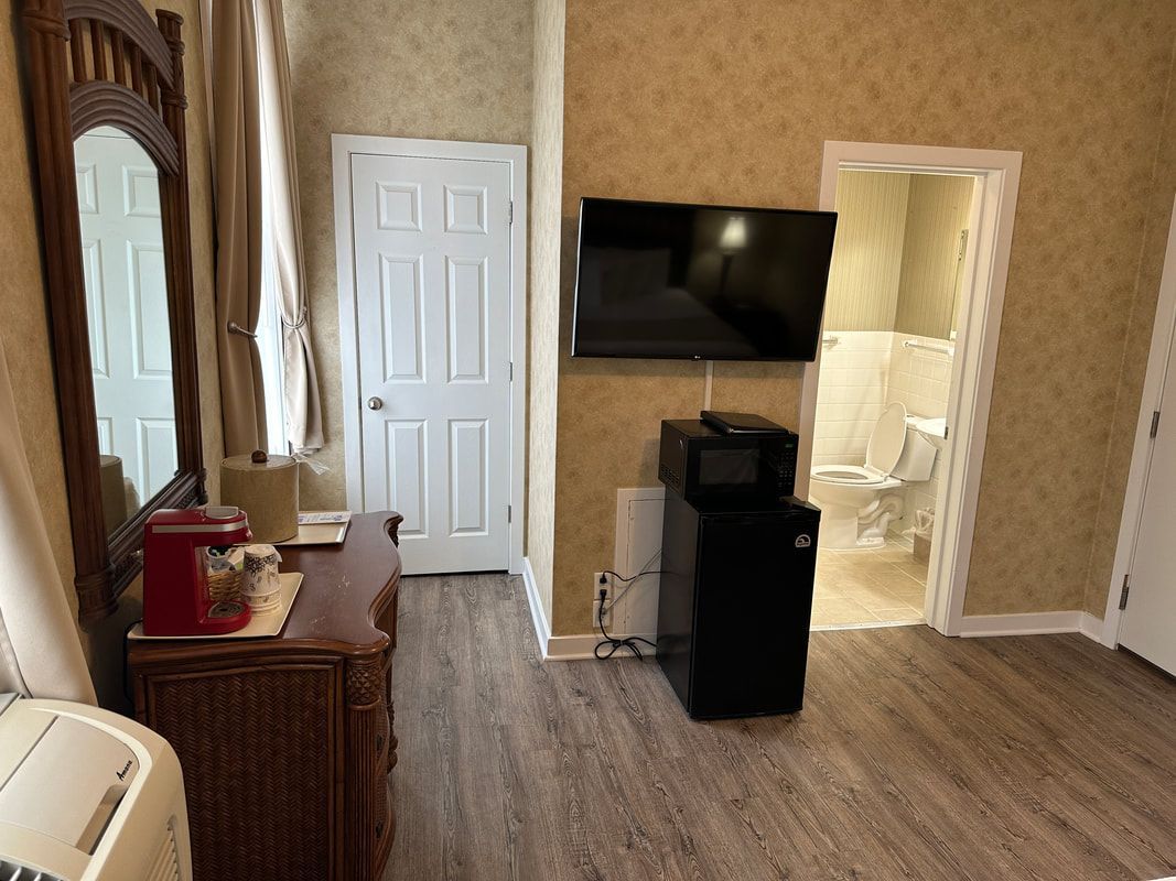 A hotel room with a flat screen tv on the wall.