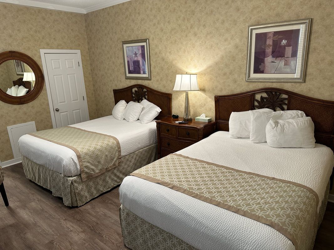 A hotel room with two beds and a mirror