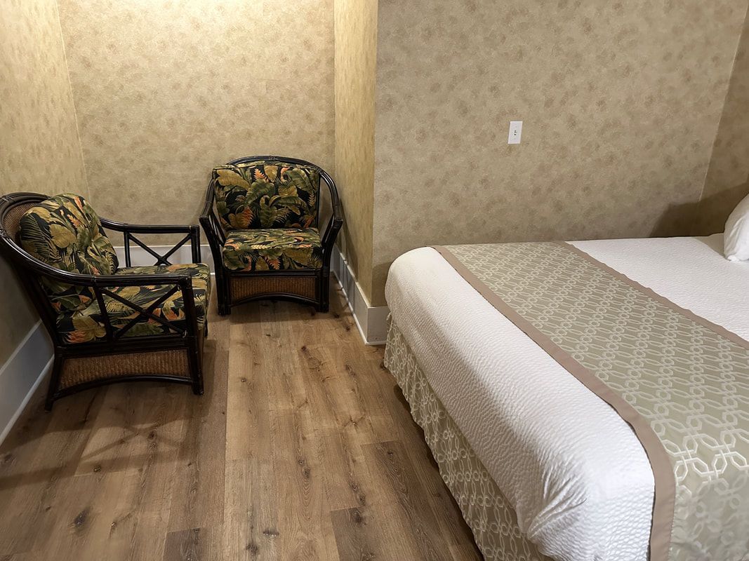There is a bed and two chairs in the room.